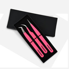 Three bright pink precision tweezers with silver metal tips, presented in an open black gift box on a light gray background.